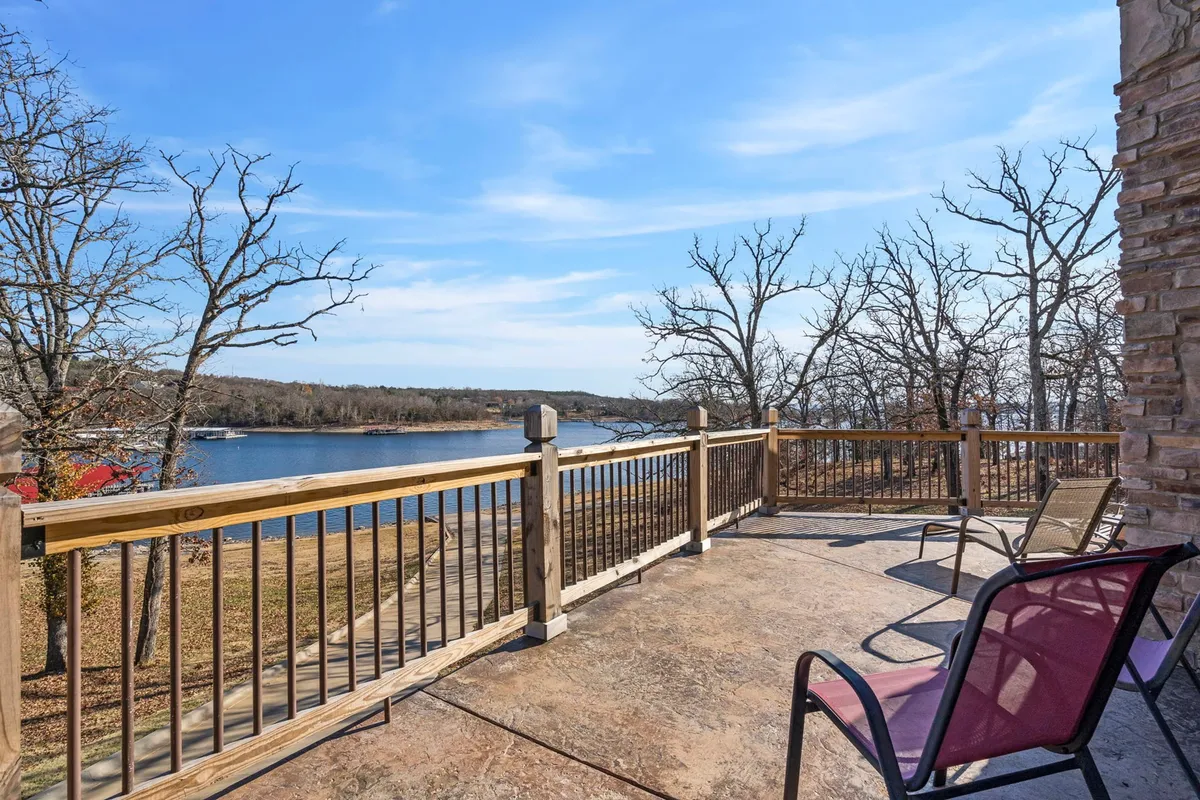 A serene outdoor deck featuring patio chairs, wooden railings, and a wide, unobstructed view of the lake. The setting is peaceful, perfect for unwinding after a day of outdoor adventures with your pet and soaking in the natural beauty.